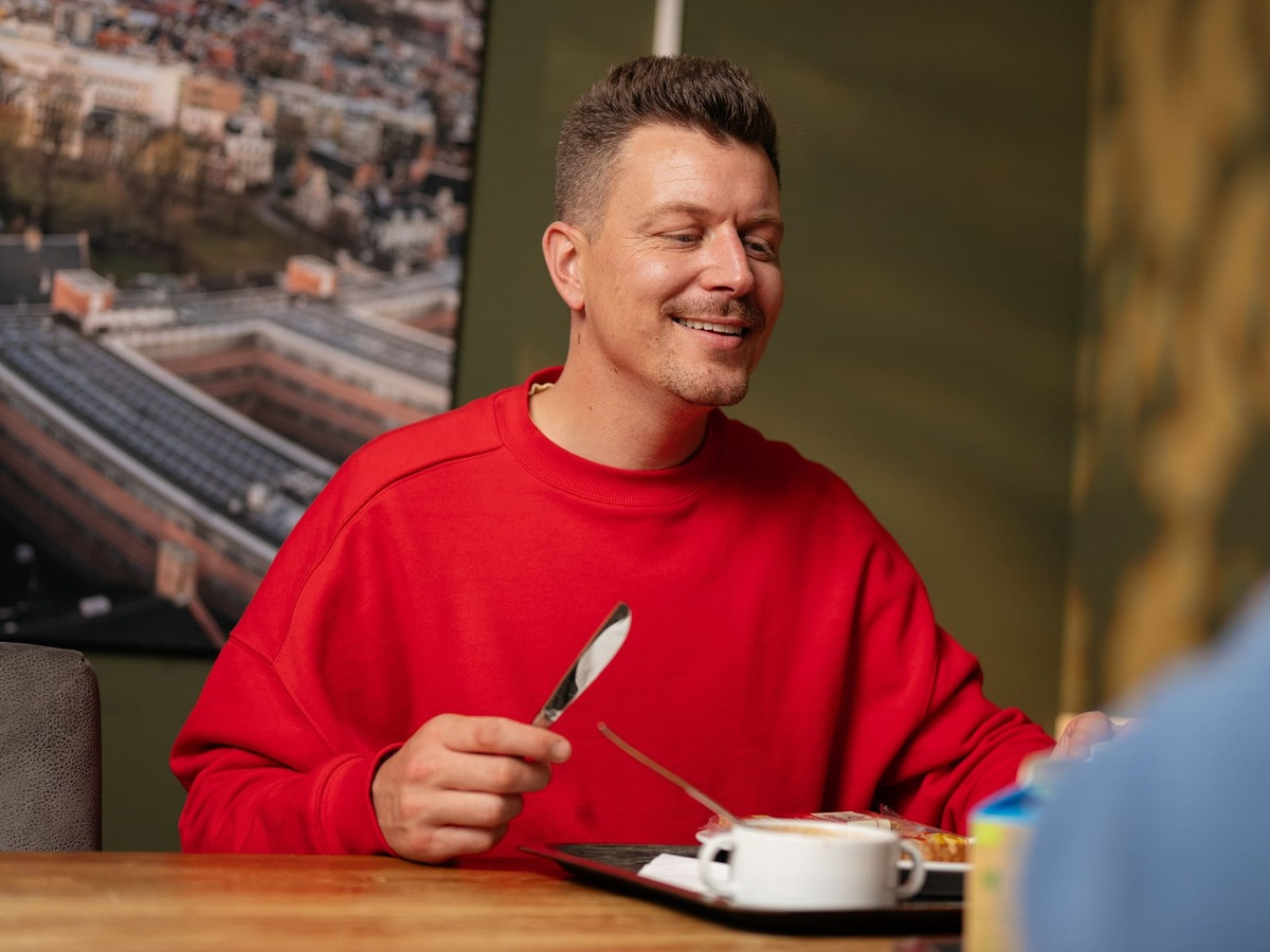 Foto van deelnemers op het balkon van het onderzoekscentrum met een glas drinken