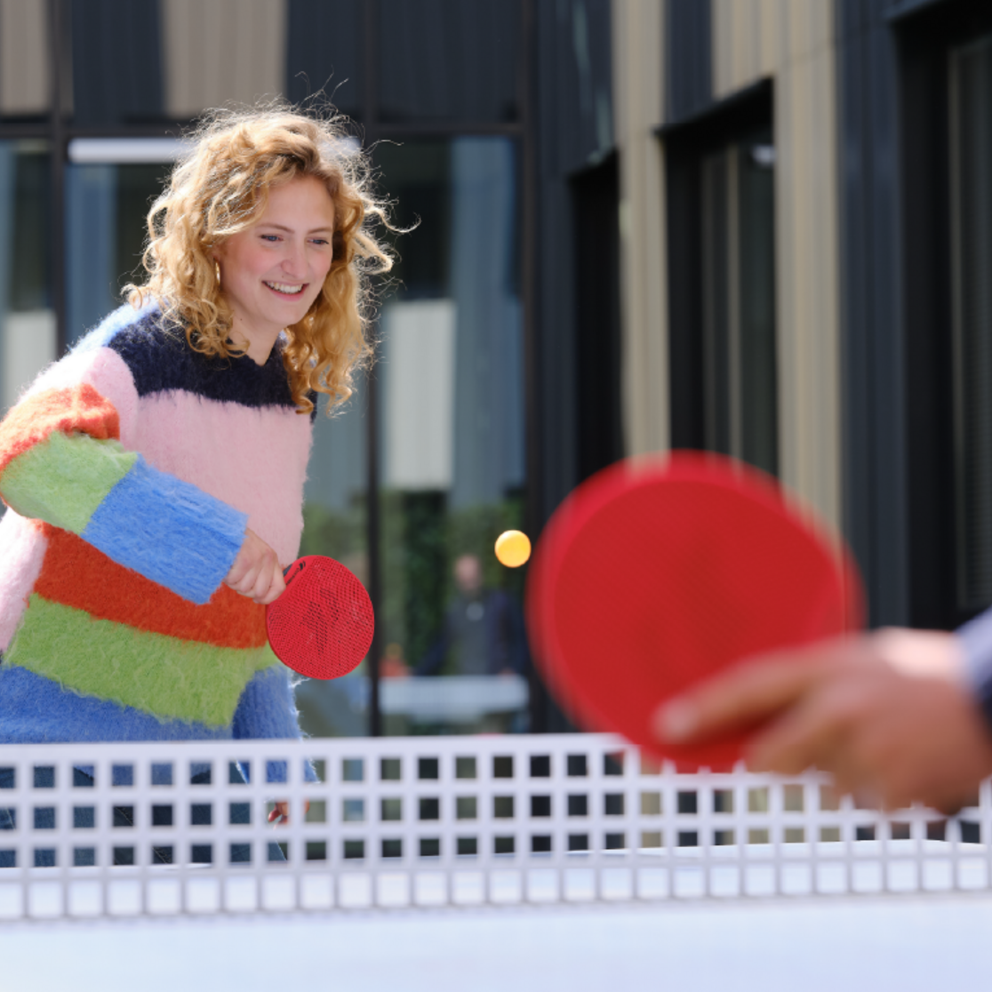 Foto van een deelnemer die aan het tafeltennissen is in de binnentuin van het onderzoekscentrum